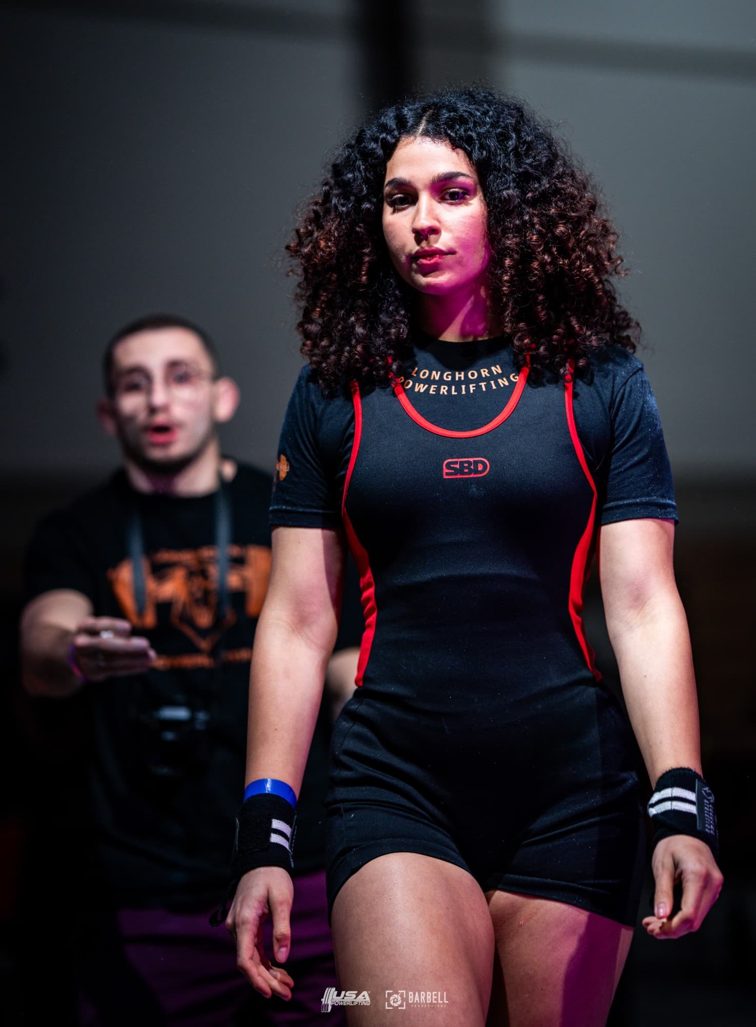 Sara Pishkar walking onto the platform in a Longhorn Powerlifting singlet